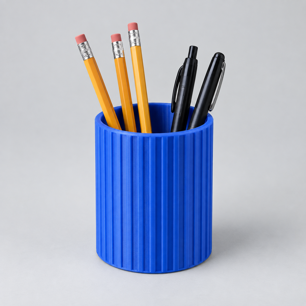 Illustrative blue 3D printed cup holding pens and pencils