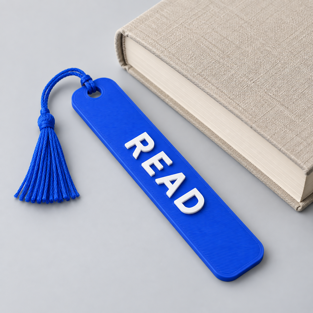 Illustrative blue personalized bookmark beside a book